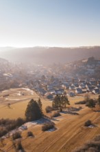 Wintery village in hilly landscape with morning sun, Glatten, Freudenstadt district, Germany