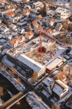 Construction site in a snowy urban area with a visible red construction crane, Zellerschule