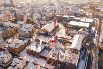 Urban winter landscape with an active construction site and red crane, Zellerschule building,