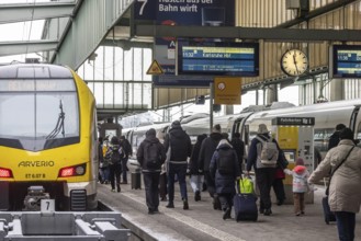 Travelers in the main train station, passengers in front of a regional train from Arverio.
