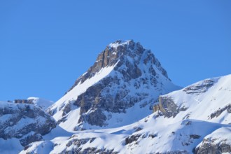 Snowy mountain peak under clear blue sky surrounded by rocks, Gemmi Pass, Leukerbad, Leuk, Valais,