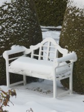 White snow upholstery on the white garden bench, East Frisia, Germany