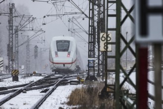 ICE traveling through a winter landscape in snowfall. A train on the line in the Deutsche Bahn