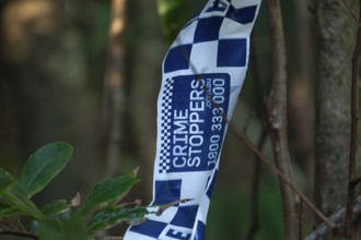 Crime scene, Byron Bay, New South Wales, Australia. Police tape blocks a forest path during an