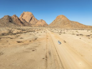 Aerial view, car on sandy road, mountains in the desert, Spitzkoppe summit, Namib desert, Namibia