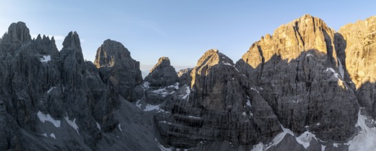 Aerial view, alpine panorama, Cima Tosa and rocky peaks at sunrise with alpine glow, picturesque