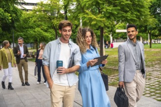 Group of diverse business professionals and entrepreneurs walking along a paved path in a green