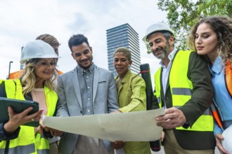 Group of multi ethnic architects, engineers, and entrepreneurs wearing hard hats and safety vests,