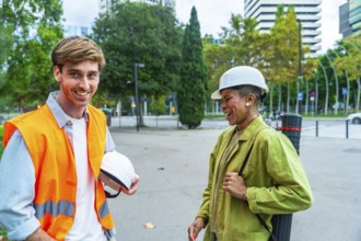 Diverse team of architects and engineers smiling and talking while standing outdoors in the city,
