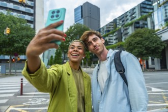Smiling multiracial young adults enjoying a moment together outdoors, capturing a selfie with a
