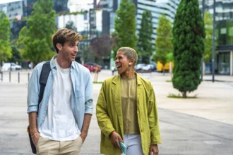 Diverse colleagues cheerfully engaging in conversation while walking together through a modern