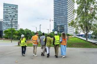Diverse team of construction professionals and architects wearing safety vests and hard hats