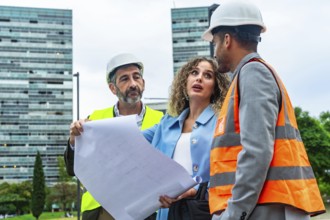 Three construction professionals, including an architect and an engineer, reviewing building