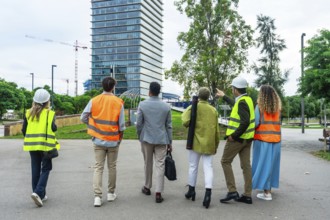 Diverse group of architects, engineers, and construction professionals walking and discussing plans