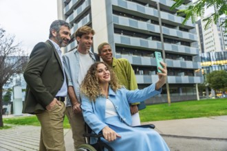 Diverse group of smiling business colleagues, including a woman in a wheelchair, capturing a selfie