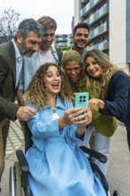 Diverse group of happy colleagues and friends, including a woman in a wheelchair, sharing a joyful