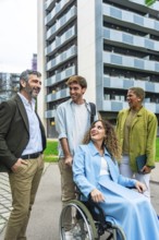 Diverse business colleagues and friends laughing and interacting outdoors in a communal city space,