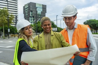 Diverse group of engineers and architects collaborating on an outdoor construction site, discussing