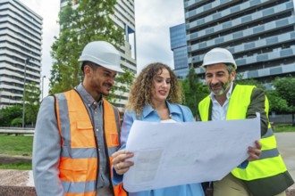 Construction team leader, architect, and engineer collaborating on a project, examining building