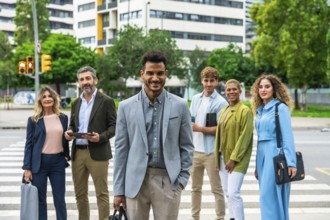 Diverse group of business people standing on a pedestrian crossing in an urban environment, smiling