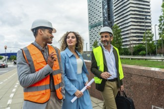 Construction professionals and architects walking outdoors in a modern city, discussing building