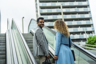 Business partners engaging in a collaborative discussion while commuting on an escalator in a