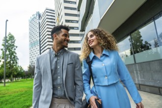 Diverse business professionals walking and smiling in a modern urban setting, conveying teamwork,
