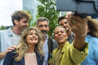 Diverse group of smiling business people and colleagues enjoying a moment together, taking a selfie