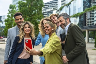 Diverse group of smiling business professionals and colleagues posing together for a group selfie