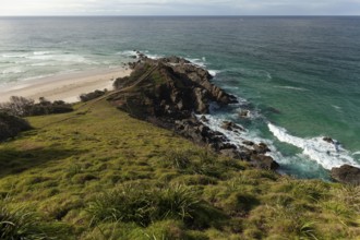 Sunlit daytime view with lookout platform below and glowing cliffs at Cape Byron, New South Wales,