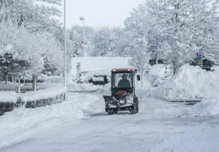 A small tractor with snow plow on snow-covered street in Ystad, Skåne County, Sweden, Scandinavia
