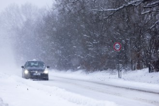 Road traffic in winter, car driving on heavily icy road covered with snow and black ice in a
