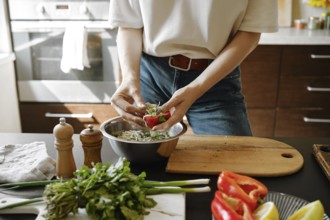 Unrecognizable woman fills bell pepper with cheese stuffing
