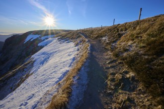 Path along a snowy mountainside at sunrise with frosty atmosphere, winter, Route de Cretes,