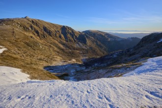 Deep snowy valley in the mountains with clear blue sky in the distance, winter, Route de Cretes,