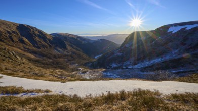 Snowy valley at sunrise with clear blue sky and bright sunbeams, winter, Route de Cretes, Hohneck,