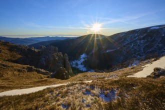 Sunrise over a snow-covered valley surrounded by mountains and rocks, winter, Route de Cretes,