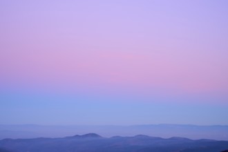 Mountain range under a calming sky in pastel shades of purple, pink and blue, looking at, Rhine