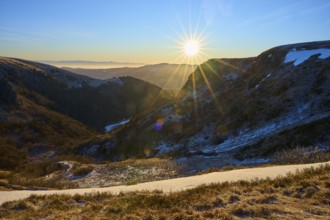 Sunrise in a snowy mountain valley with rays of light and a clear view, morning, winter, Hohneck,