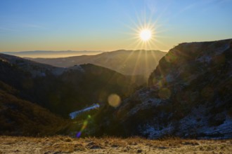 Sunrise over a snowy mountain valley with clear sky and rays of light, morning, winter, Hohneck, La