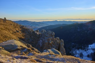 Quiet mountain landscape with rocks in the foreground and blue sky in the background, view of the