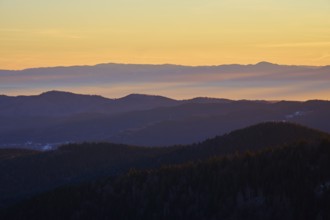 Mountains in silhouette at sunrise in warm shades of orange and yellow, view, Rhine Valley,