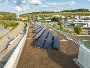 Row of solar modules on a sloping roof in an urban landscape, new park and ride parking garage Calw