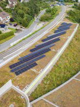 Solar system on a green roof next to railway tracks with urban surroundings, new park and ride