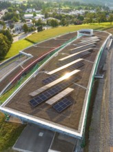 A roof area with solar panels, illuminated by the evening sun, in a rural area, new park and ride