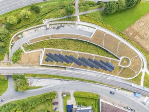 Large solar systems on a covered parking lot surrounded by roads and greenery, new Park and Ride