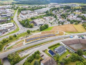 City panorama with solar systems on a hill in the middle of industrial buildings, new park and ride
