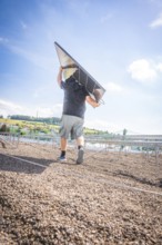 Person carrying a solar panel on a sunlit building site, new park and ride parking garage Calw