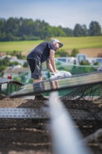 Workers installing a solar system on a roof with a view of the surrounding area, new park and ride