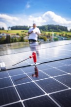 Close-up of a solar module with a working person in a rural area, new Park and Ride parking garage